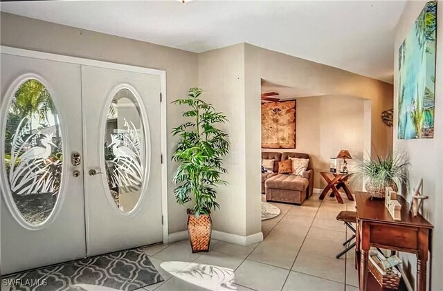 717 SW 49th Ln, Cape Coral, FL 33914 - entryway with french doors, light tile patterned floors, and baseboards