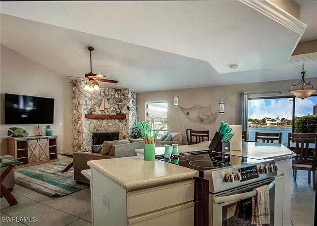 717 SW 49th Ln, Cape Coral, FL 33914 - kitchen featuring stainless steel electric range, ceiling fan, a fireplace, light tile patterned floors, and light countertops