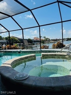 717 SW 49th Ln, Cape Coral, FL 33914 - swimming pool with an in-ground hot tub, glass enclosure, and a water view