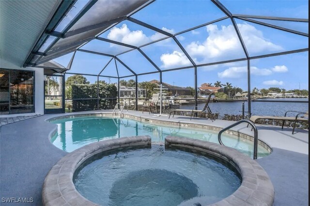 717 SW 49th Ln, Cape Coral, FL 33914 - view of pool featuring a pool with connected hot tub, a water view, and a patio