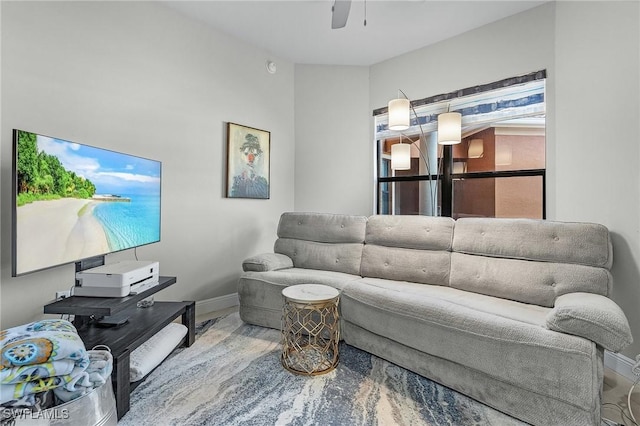 living area featuring a ceiling fan and baseboards
