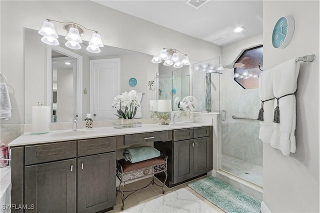 bathroom featuring double vanity, visible vents, a shower stall, and a sink