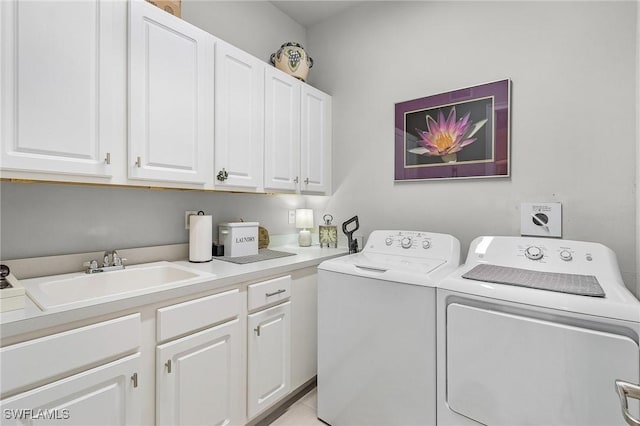 laundry area with separate washer and dryer, a sink, and cabinet space