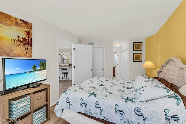 bedroom featuring visible vents and wood finished floors