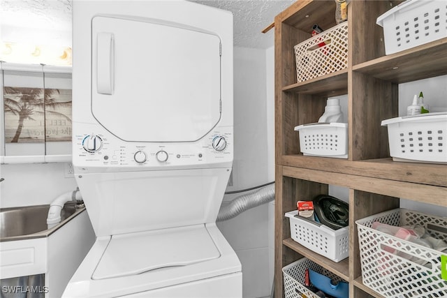 washroom featuring a textured ceiling, laundry area, and stacked washer / dryer