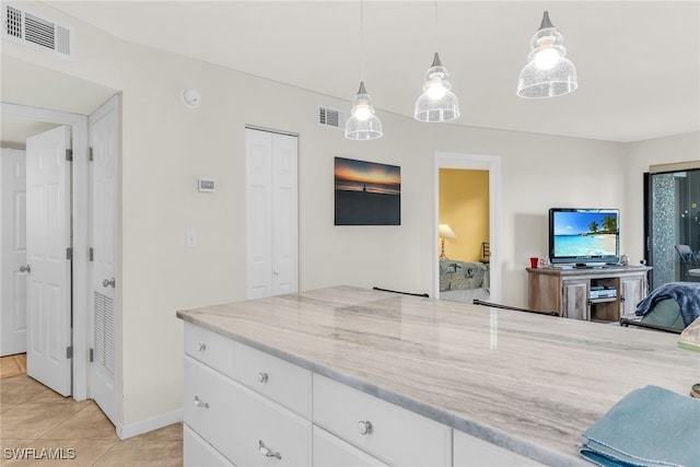 interior space with baseboards, light tile patterned flooring, and visible vents