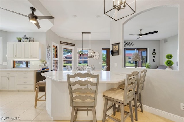 interior space with visible vents, light tile patterned floors, and ceiling fan with notable chandelier