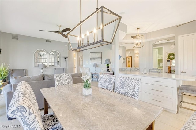 dining space with visible vents, arched walkways, a ceiling fan, and light tile patterned floors