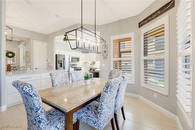 dining room with baseboards, light tile patterned flooring, and a chandelier