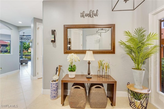 hallway featuring baseboards, tile patterned flooring, and recessed lighting