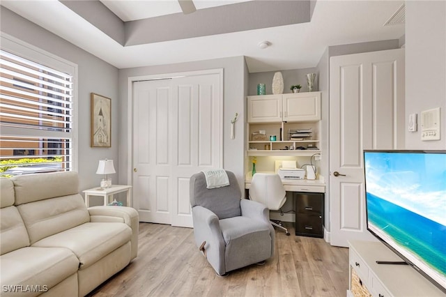 sitting room featuring light wood-type flooring, ceiling fan, and visible vents