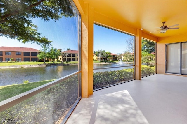 unfurnished sunroom featuring a water view and concrete flooring