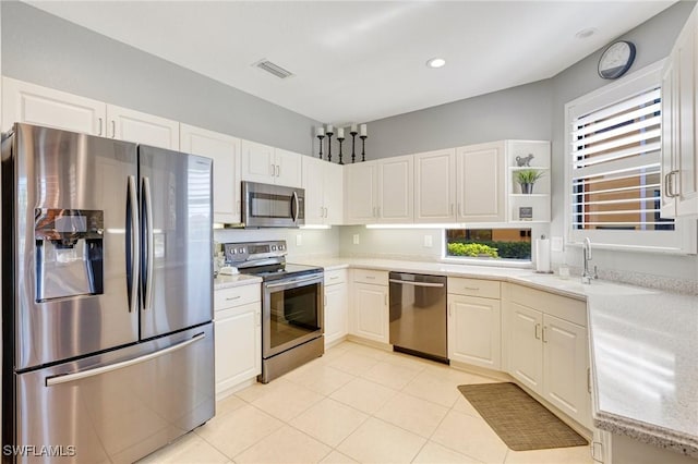 kitchen with white cabinets, open shelves, a sink, stainless steel appliances, and visible vents