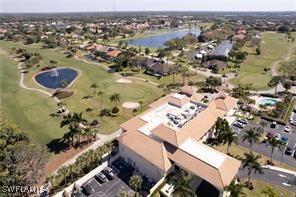 aerial view of property's location with a large body of water, a golf course, and nearby suburban area