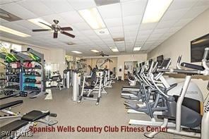 exercise room with ceiling fan and a paneled ceiling