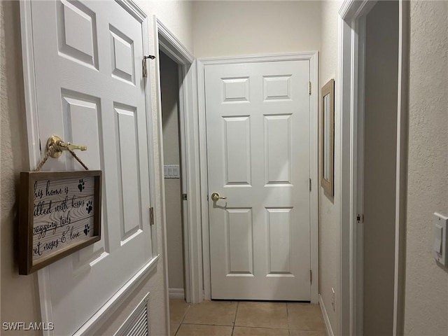 hall featuring light tile patterned floors