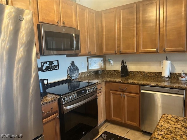 9631 Spanish Moss Way Unit 3931, Bonita Springs, FL 34135 - kitchen featuring appliances with stainless steel finishes, light tile patterned flooring, and dark stone countertops