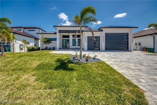 view of front of house featuring an attached garage, decorative driveway, a front lawn, and stucco siding