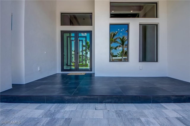 view of exterior entry with french doors and stucco siding