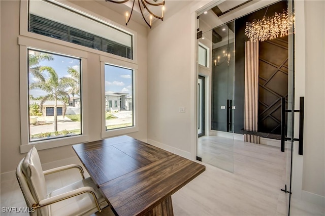 unfurnished office featuring an inviting chandelier, baseboards, and a wealth of natural light