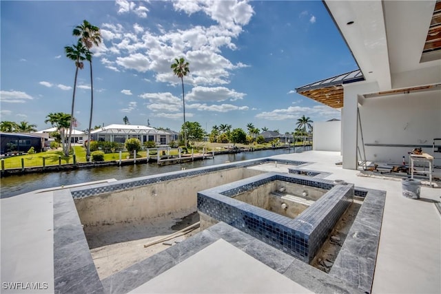 view of pool featuring a water view and an in ground hot tub