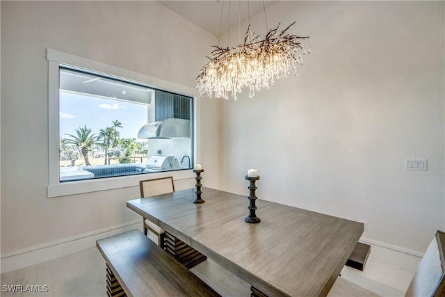 dining space featuring an inviting chandelier and baseboards