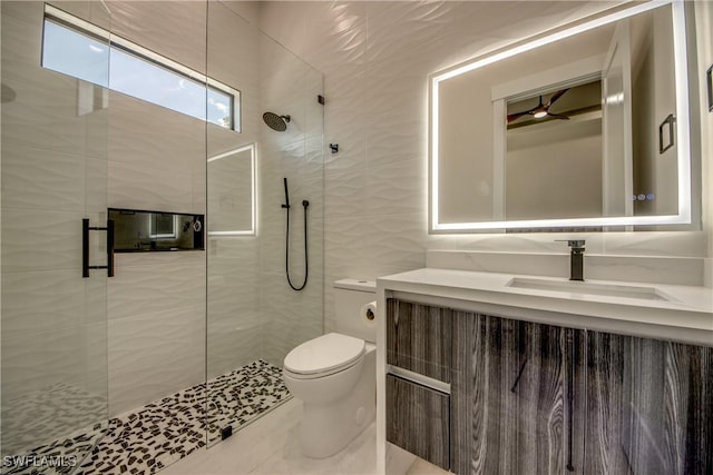 full bathroom featuring toilet, tile walls, a shower stall, and vanity