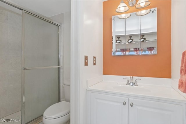 bathroom featuring toilet, a shower stall, and vanity