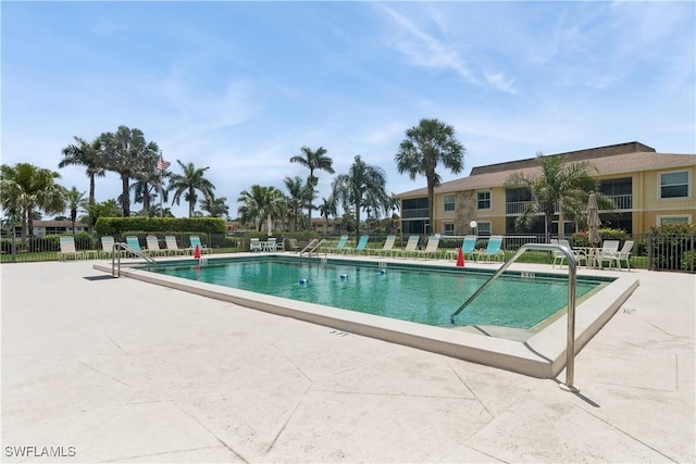 community pool featuring fence and a patio area