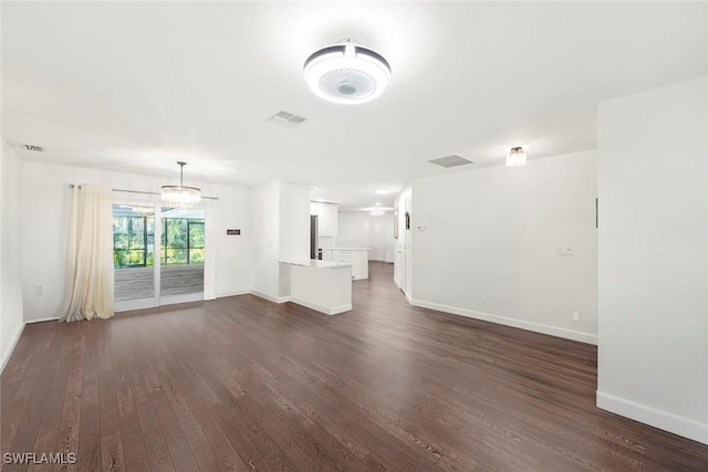 6012 Perthshire Ln, Fort Myers, FL 33908 - unfurnished living room featuring dark wood-style flooring, baseboards, and a chandelier