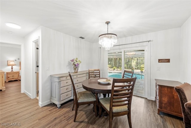 6012 Perthshire Ln, Fort Myers, FL 33908 - dining area with wood finished floors, a chandelier, and baseboards