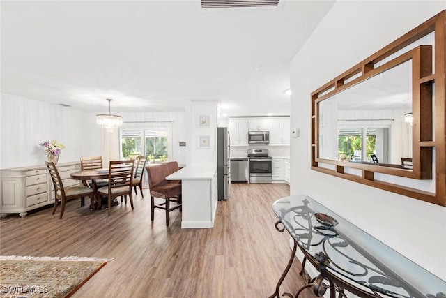 6012 Perthshire Ln, Fort Myers, FL 33908 - kitchen featuring appliances with stainless steel finishes, light countertops, light wood-type flooring, and plenty of natural light