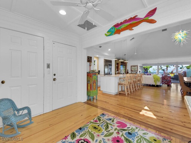 8315 Main St, Bokeelia, FL 33922 - foyer with ceiling fan, visible vents, beamed ceiling, light wood finished floors, and ornamental molding