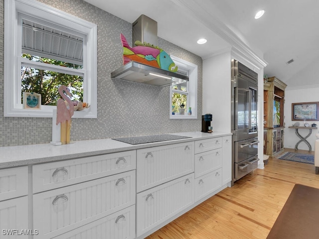 8315 Main St, Bokeelia, FL 33922 - kitchen with white cabinets, light wood finished floors, built in fridge, tasteful backsplash, and visible vents