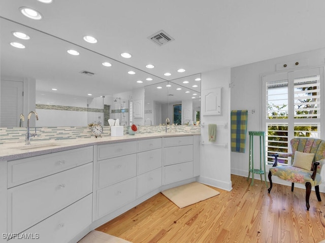 8315 Main St, Bokeelia, FL 33922 - full bath featuring visible vents, double vanity, wood finished floors, a sink, and a stall shower