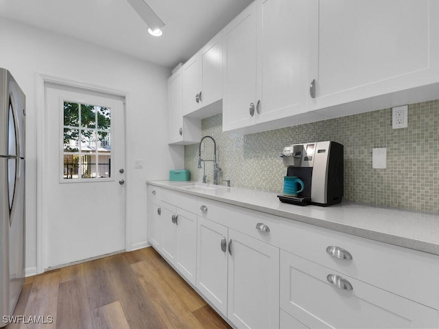 8315 Main St, Bokeelia, FL 33922 - kitchen with a sink, light countertops, white cabinets, and freestanding refrigerator