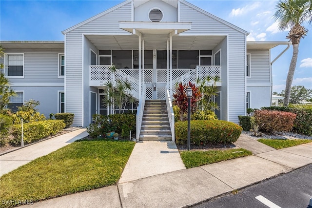 15400 River Vista Dr Unit 304, North Fort Myers, FL 33917 - view of front of house with stucco siding, a sunroom, and stairway