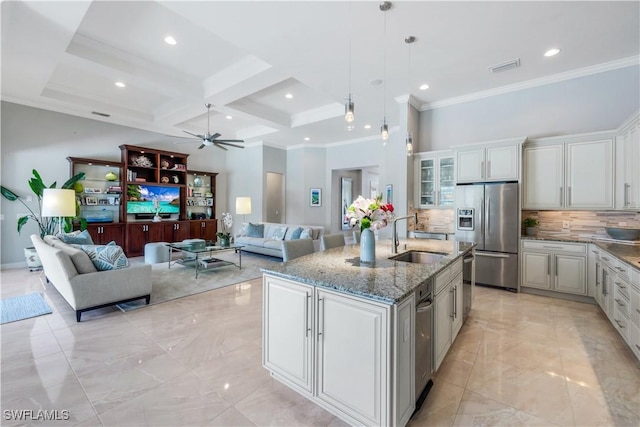 9052 Graphite Cir, Naples, FL 34120 - kitchen featuring appliances with stainless steel finishes, a sink, a ceiling fan, decorative backsplash, and light stone counters