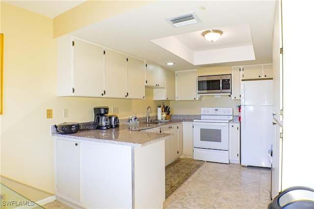 7116 Lakeridge Ct Unit 103, Fort Myers, FL 33907 - kitchen featuring a sink, a raised ceiling, visible vents, white appliances, and a peninsula