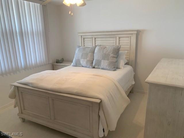 bedroom featuring ceiling fan, baseboards, and light carpet