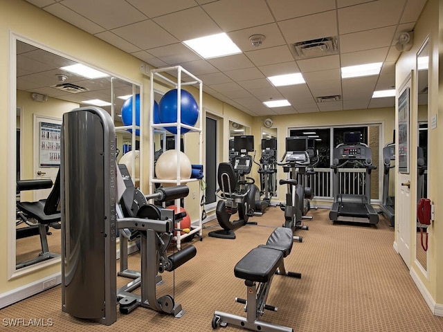 workout area featuring visible vents, carpet flooring, and a paneled ceiling