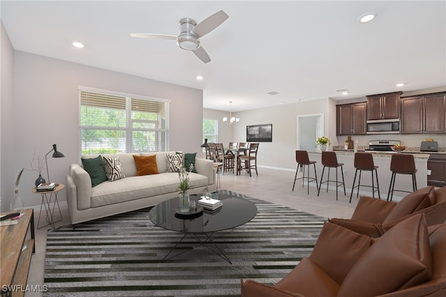 3078 Birchin Ln, Fort Myers, FL 33916 - living area featuring light tile patterned flooring, recessed lighting, ceiling fan with notable chandelier, and baseboards