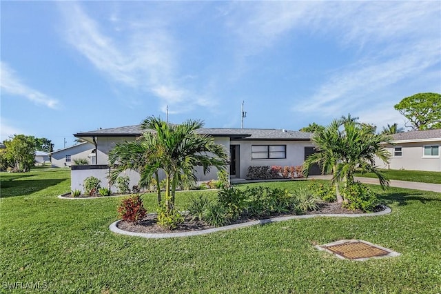 view of front of property with stucco siding, driveway, a front yard, and a garage