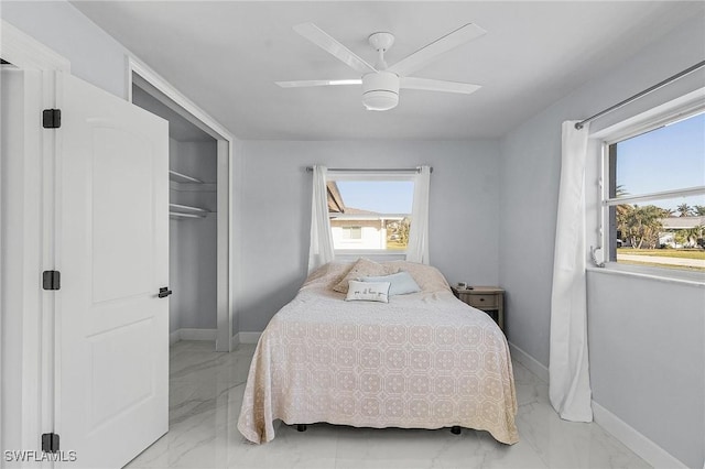 bedroom with baseboards, a ceiling fan, a closet, and marble finish floor