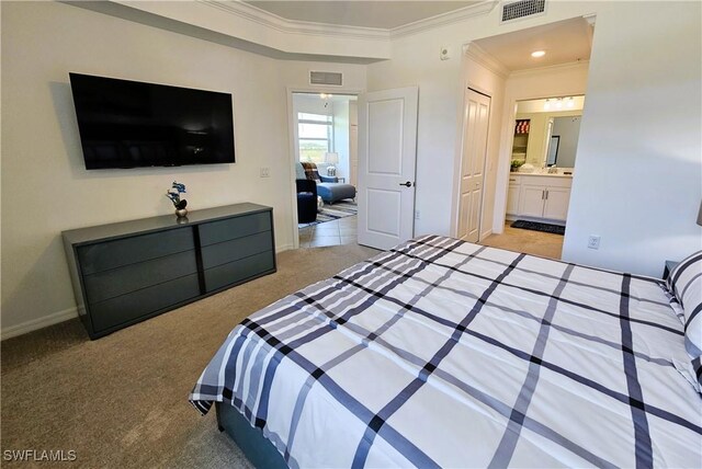 bedroom featuring crown molding, visible vents, light colored carpet, and ensuite bath