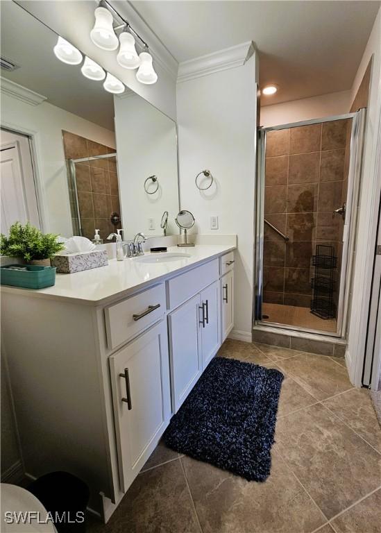 full bathroom featuring tile patterned flooring, a shower stall, vanity, visible vents, and crown molding