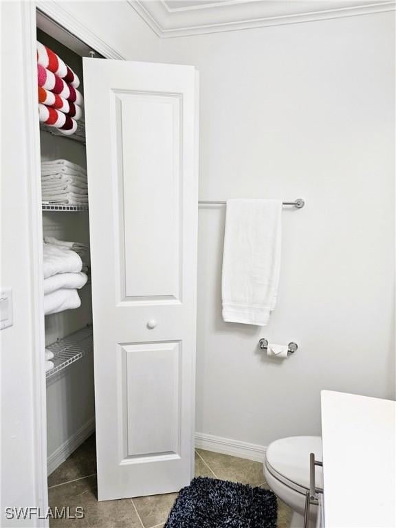 bathroom featuring baseboards, tile patterned flooring, and crown molding