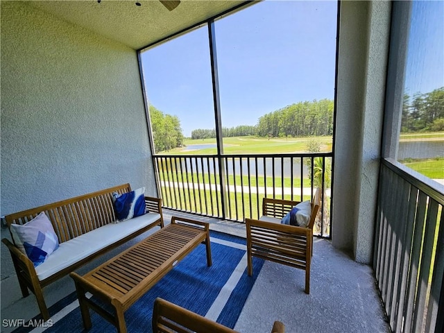 sunroom / solarium featuring a water view, outdoor lounge area, and view of golf course