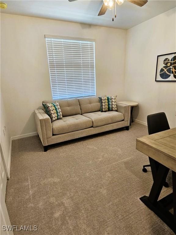 carpeted living room featuring baseboards and a ceiling fan