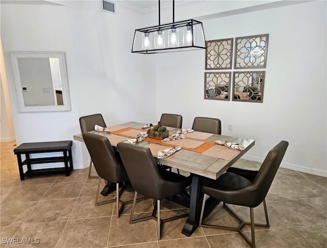 tiled dining area featuring crown molding, visible vents, and baseboards